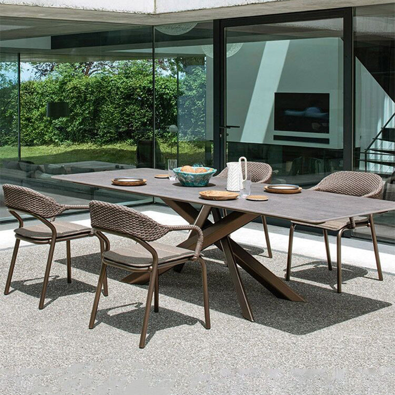 Spacious outdoor dining table with rattan chairs in a serene garden setting