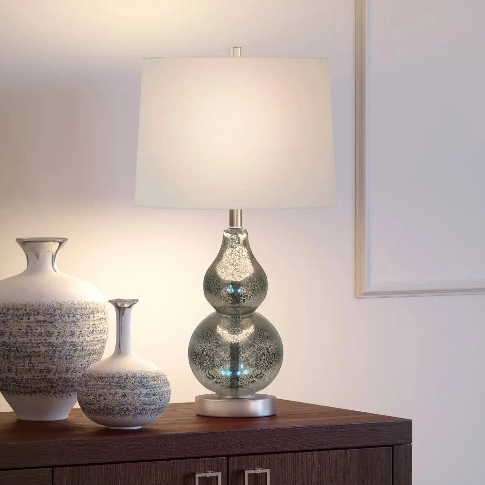 Elegant gourd-shaped metal table lamp featuring a glossy silver finish and fabric shade, ideal for bedside use.