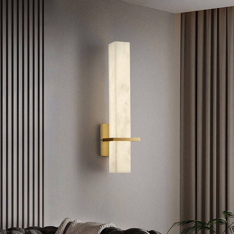 Close-up of the square marble shade and golden base of the wall lamp.