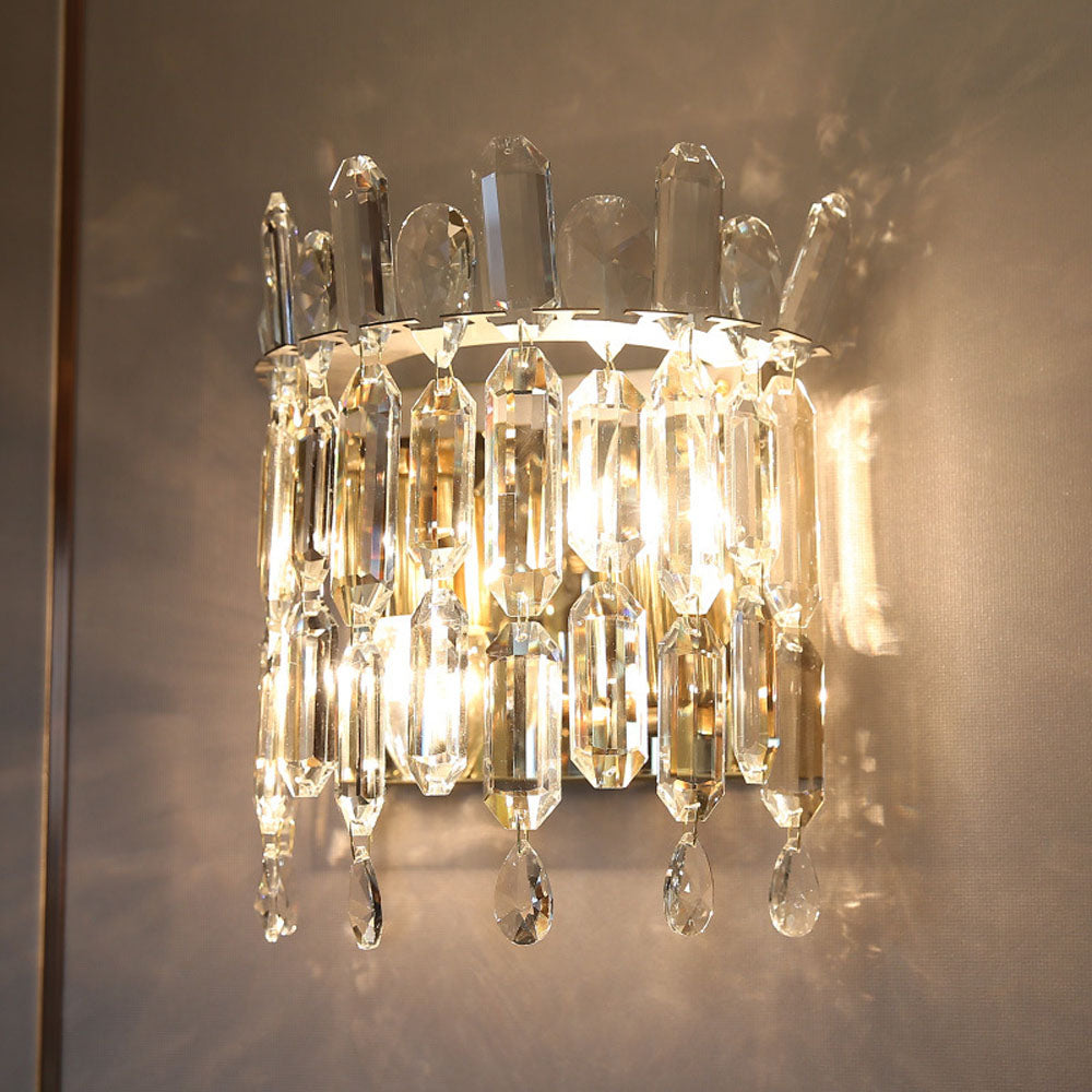 Gold crystal wall lamp in a cozy bedroom setting, illuminating the space beautifully.