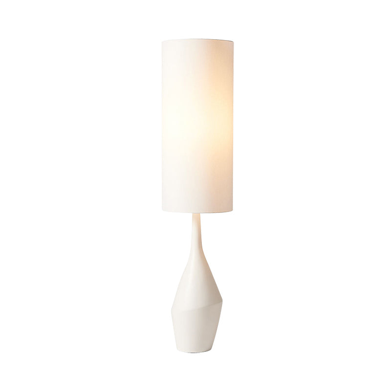 A side view of the Nordic Elegance Cream LED Floor Lamp illuminating a cozy reading nook.