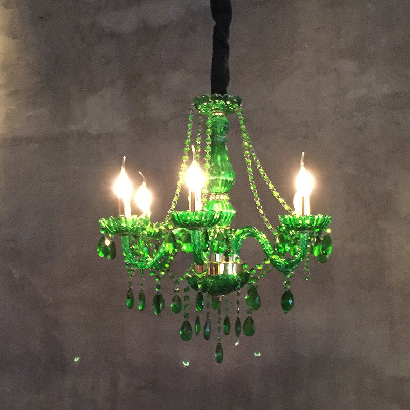 Elegant green chandelier light illuminating a cozy living room space.