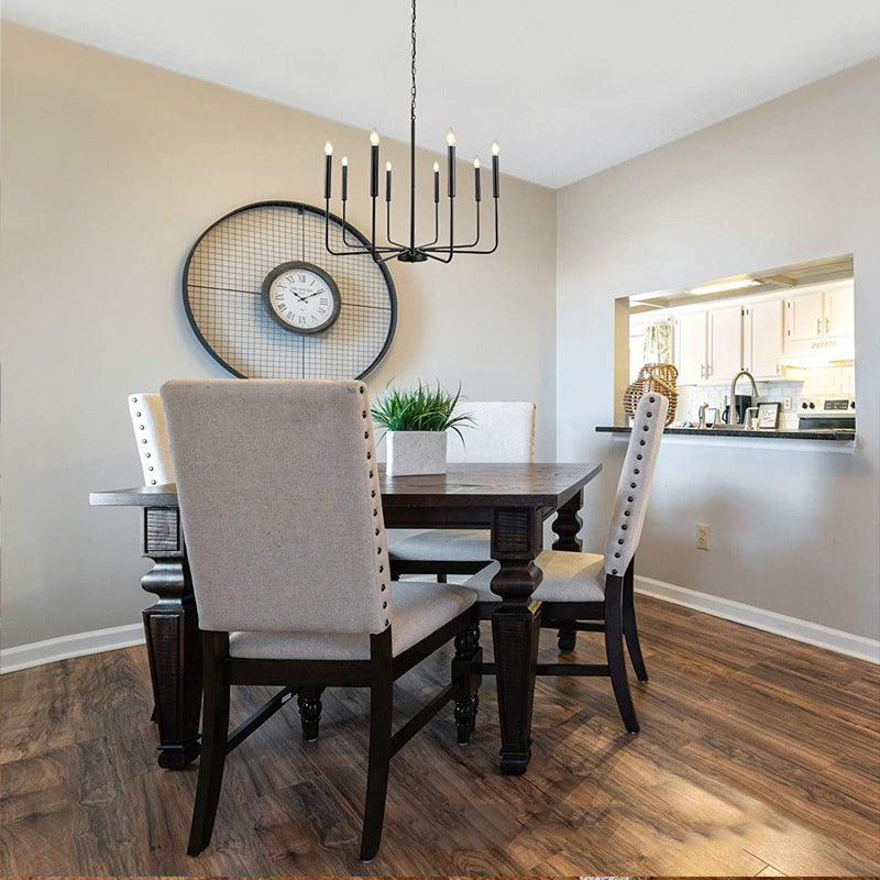 Rustic Elegance Brass Candle Pendant Light hanging above a dining table, creating a cozy atmosphere.