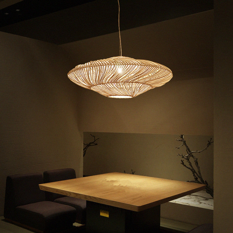Rattan pendant light illuminating a cozy dining room, highlighting its warm glow.