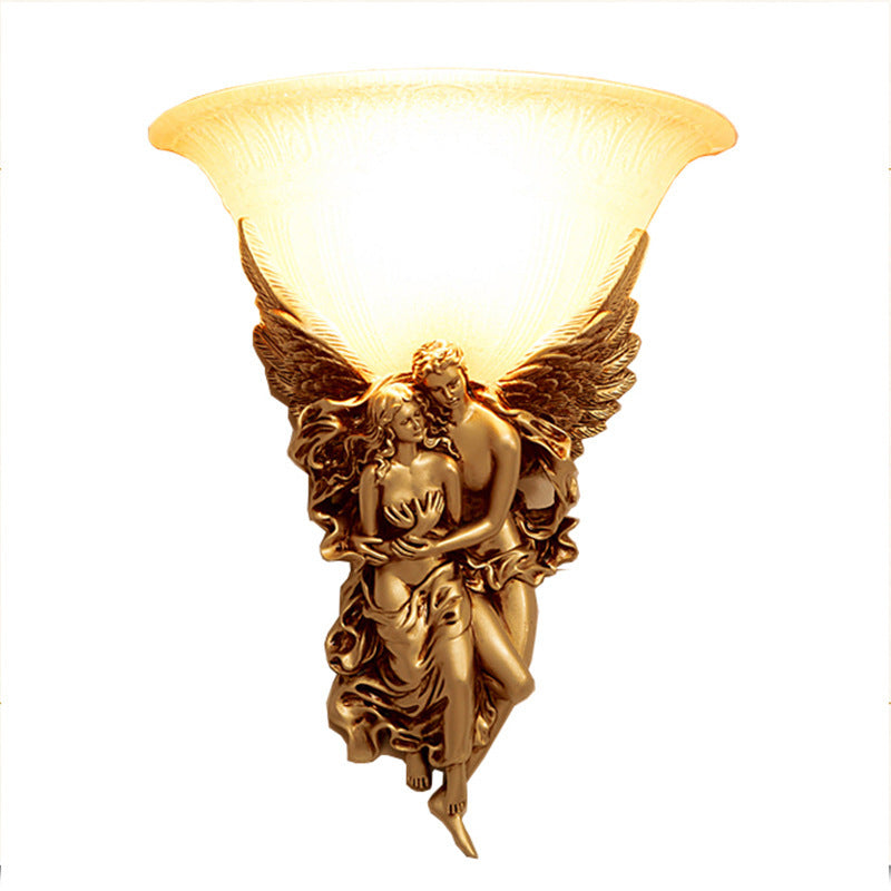 Elegant gold resin angel wall sconce illuminating a stylish living room.