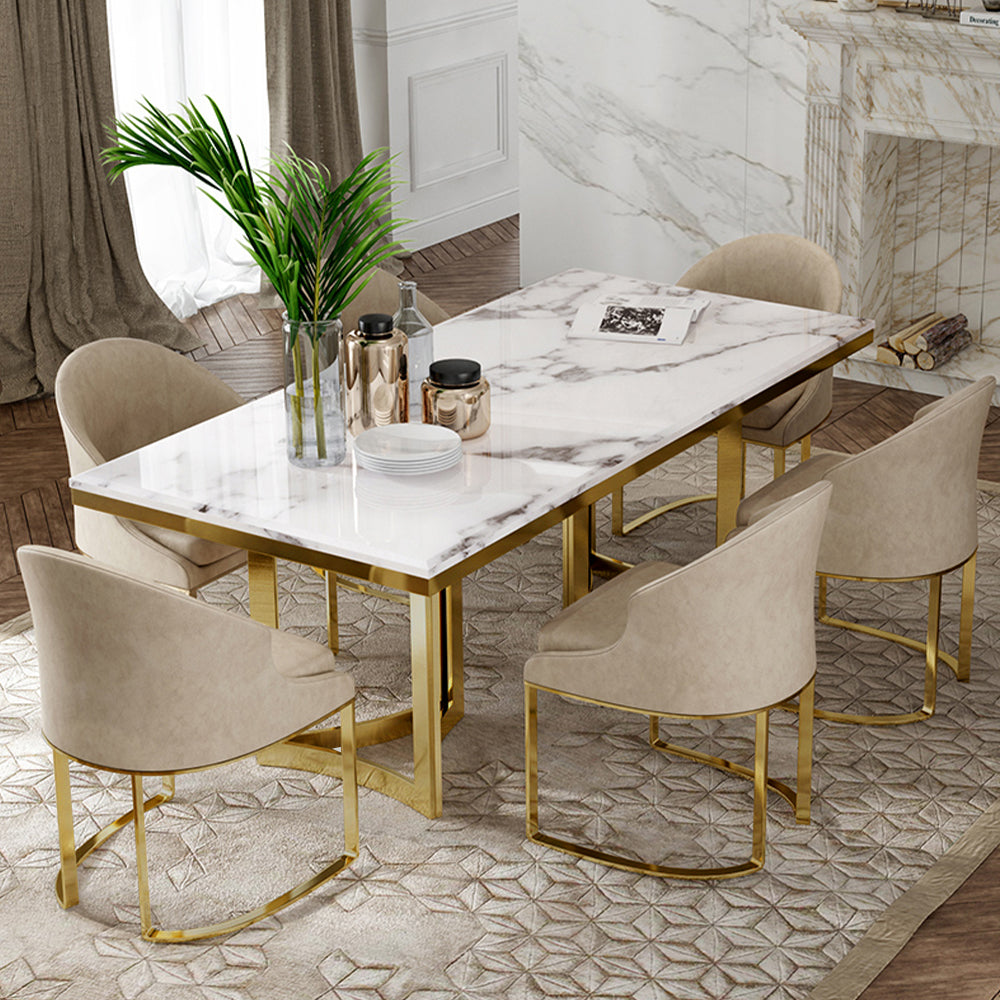 Elegant white marble dining table with gold legs from a side angle.