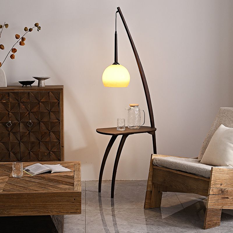 Elegant modern floor lamp with phone shelf in cozy living room.