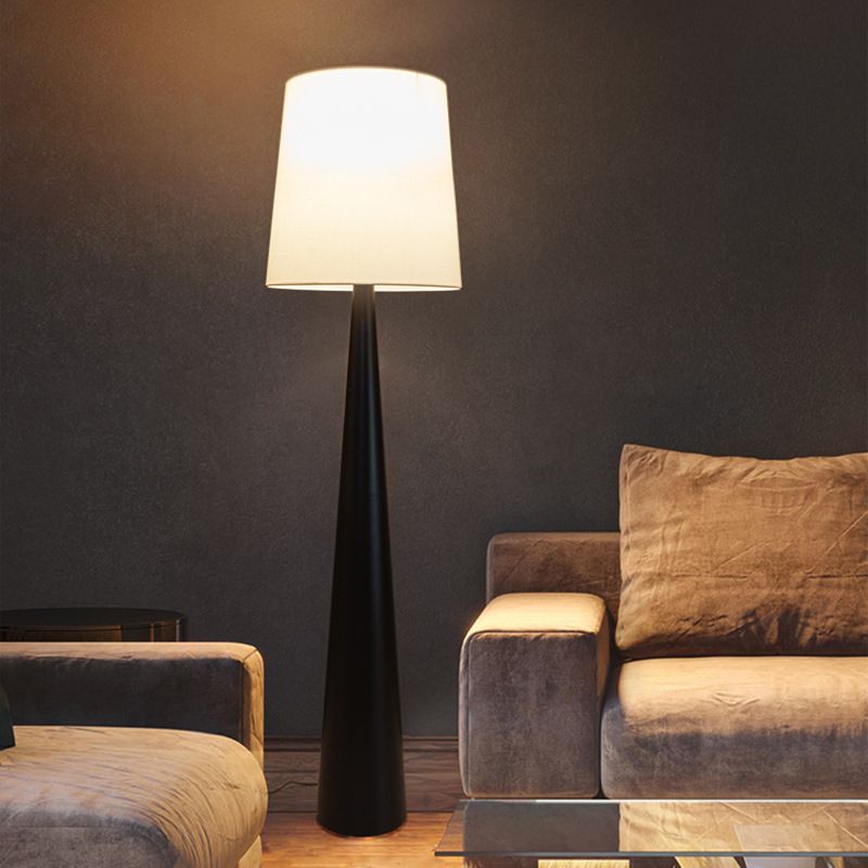 Elegant black cone floor lamp with round base in a stylish living room setting.