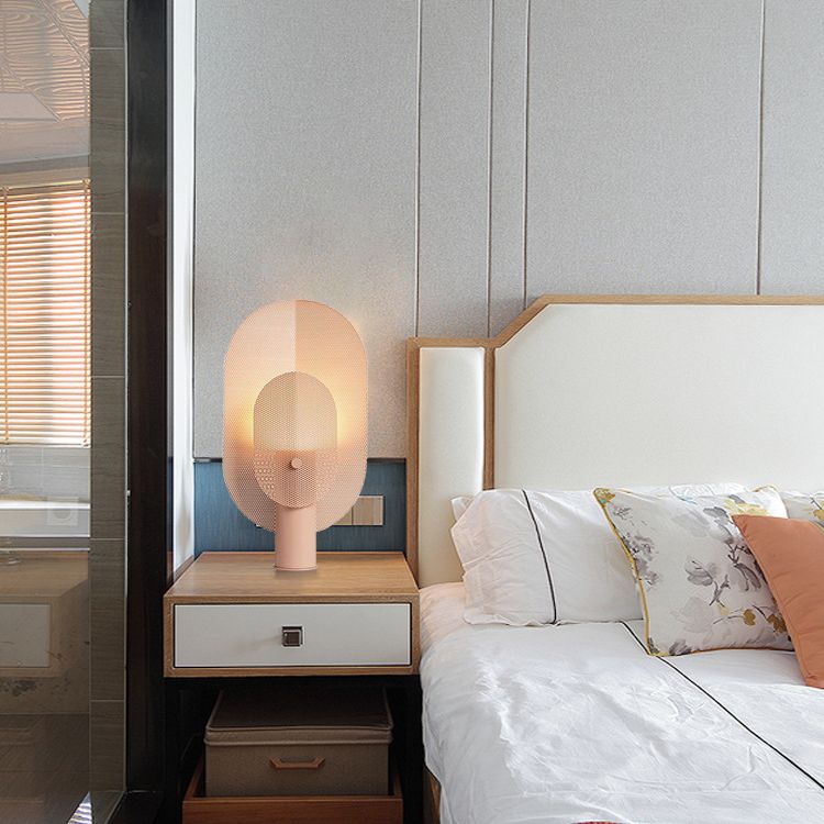 Chic pink iron filter table lamp showcasing its unique design from a side angle.