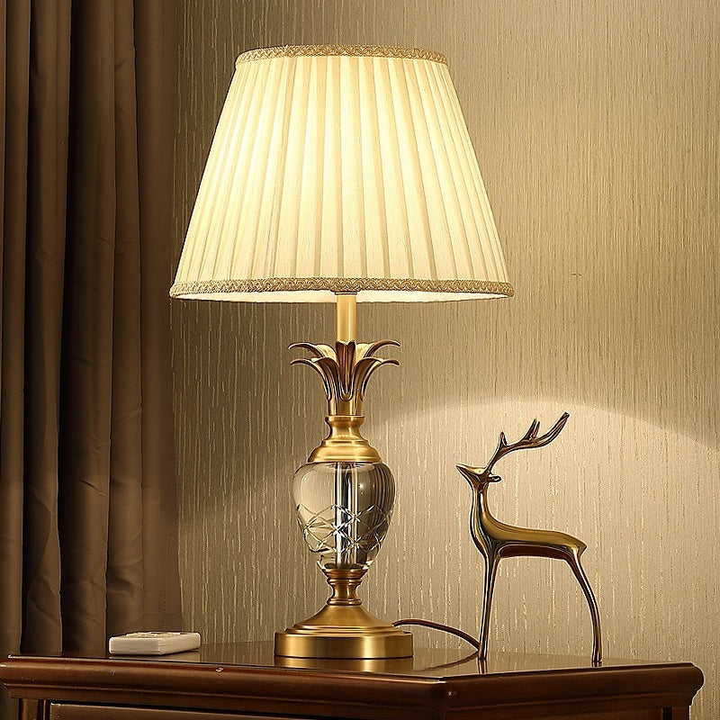 Elegant modern copper crystal table lamp on a bedside table with warm light
