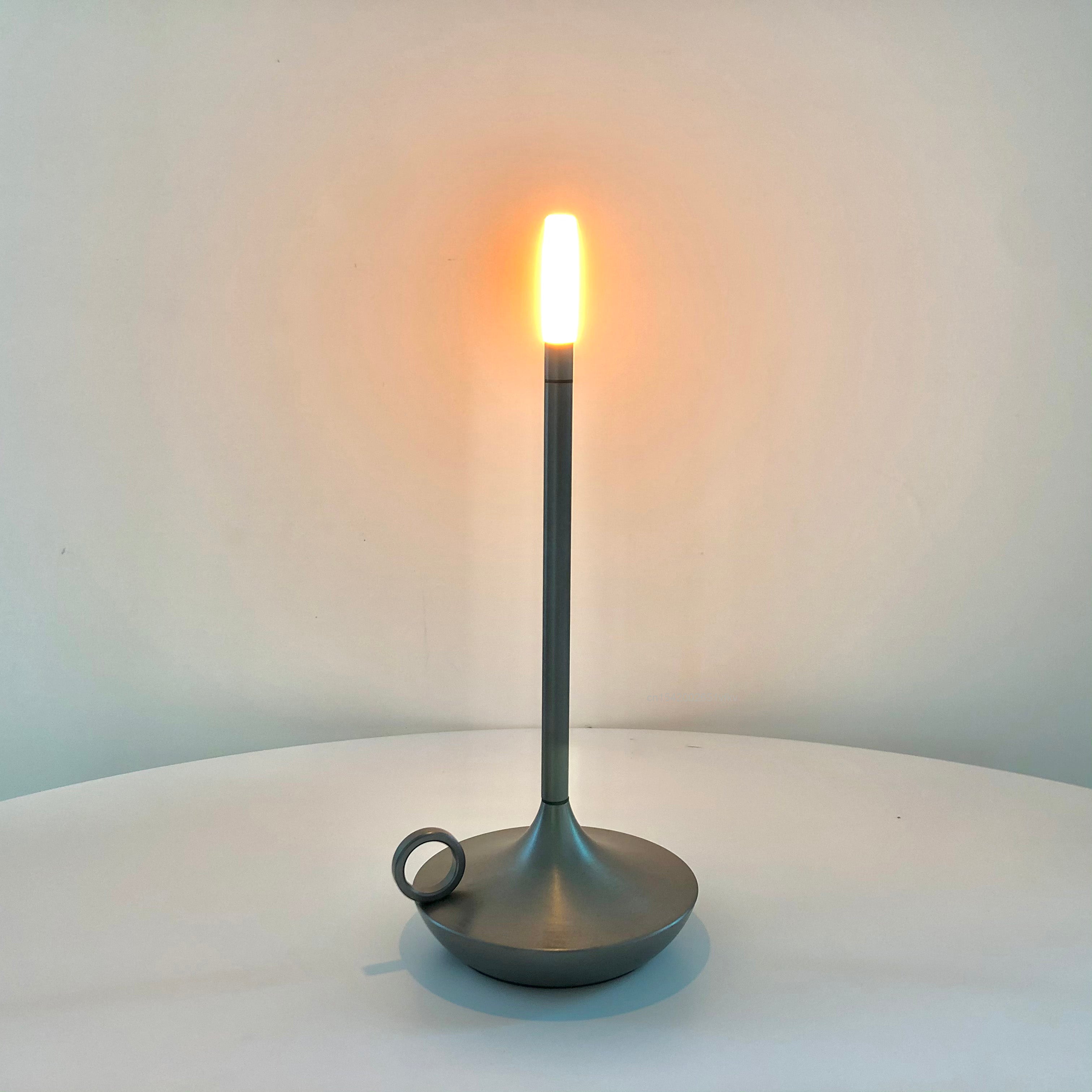 Close-up of the touch on/off switch of the rechargeable lamp, highlighting its sleek design.