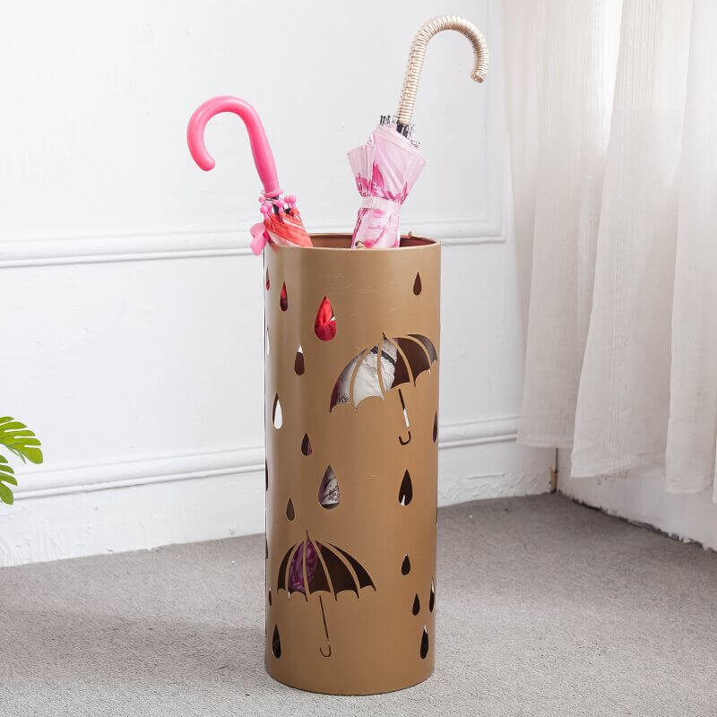Elegant metal umbrella holder showing intricate carvings, placed in a modern hallway.