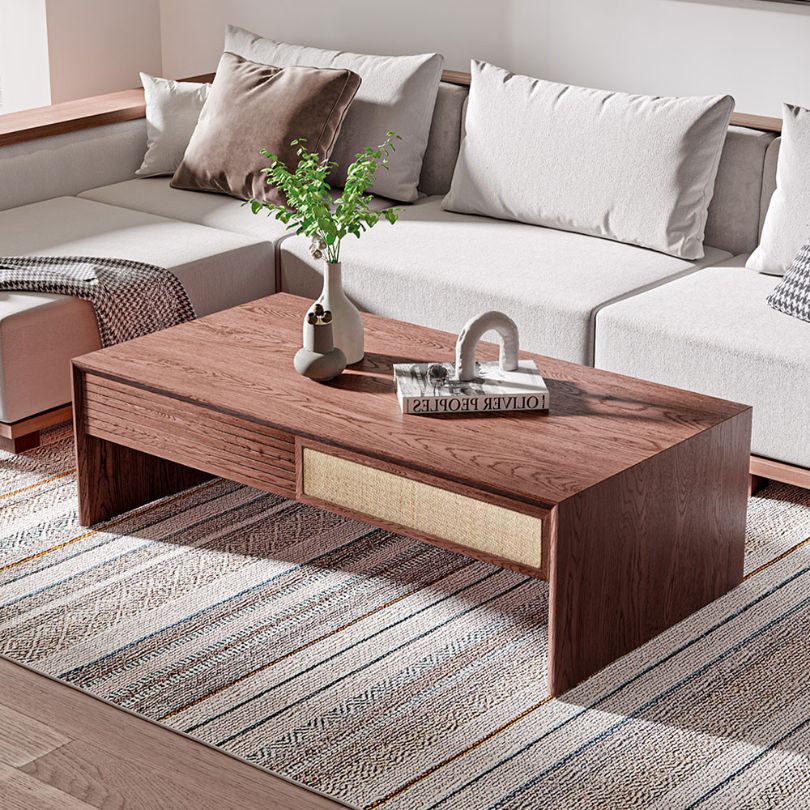 Elegant modern coffee table with storage drawers, showcasing its polished surface and rattan design.