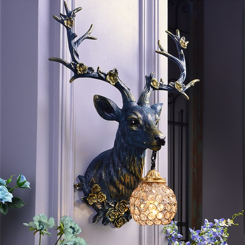 Front view of the deer wall sconce in white finish with floral antlers mounted in a cottagecore bedroom.
