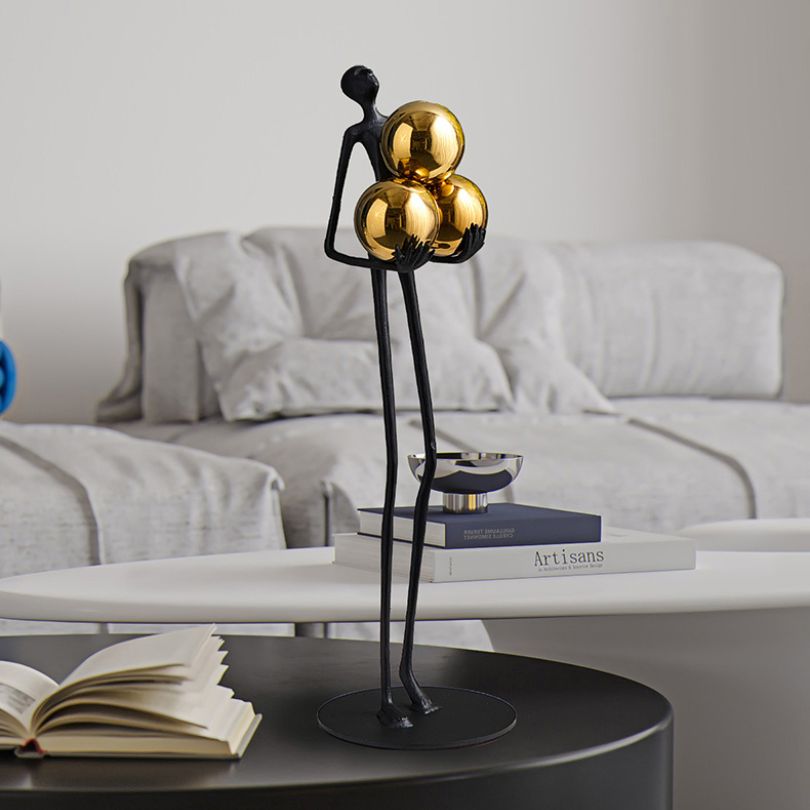 Front view of the Chic Miniature Human Statue with Golden Sphere in a modern living room.