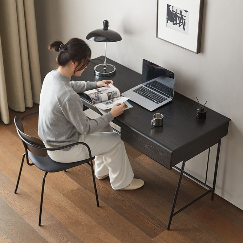 Top-down view of the black desk with a laptop, lamp, and decorative items arranged for an inspiring workspace.