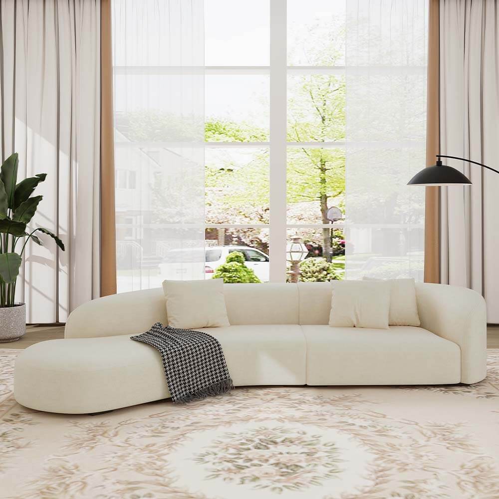 Chic curved beige sofa from side angle, showcasing its elegant design.