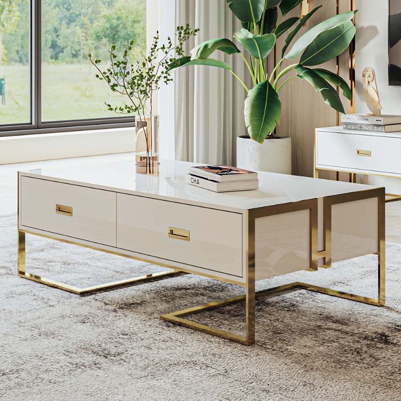 Elegant gold accent coffee table showcasing the sleek design and spacious drawers from a side angle.
