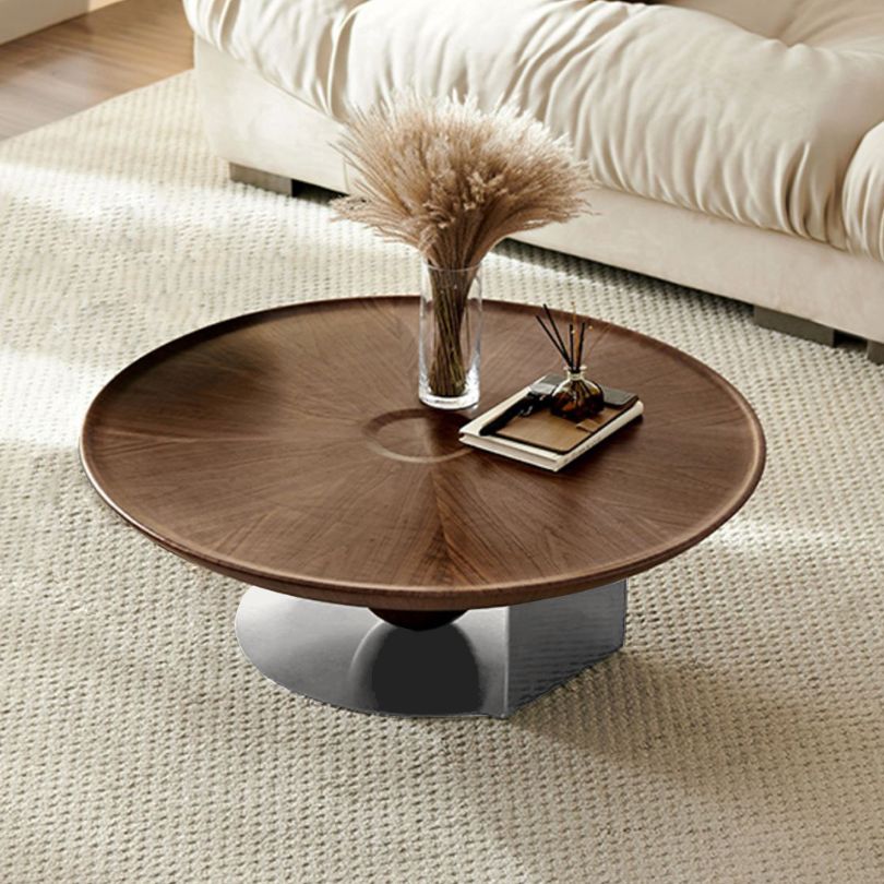 Front view of the stylish round wood coffee table with a steel base in a contemporary living room setting.