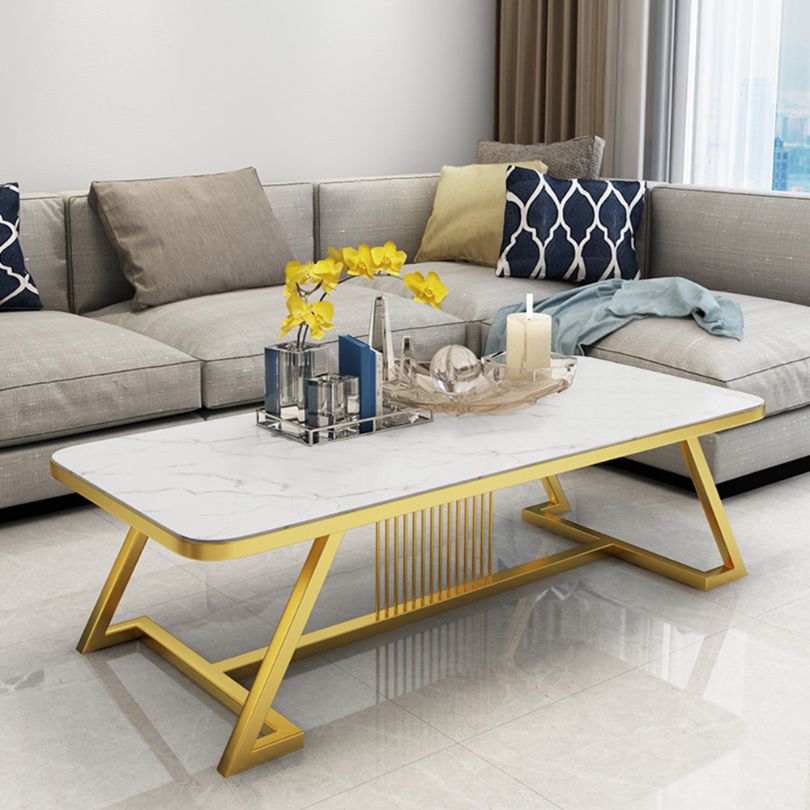 Front view of the stylish white faux marble coffee table with a gold frame in a contemporary living room setting.