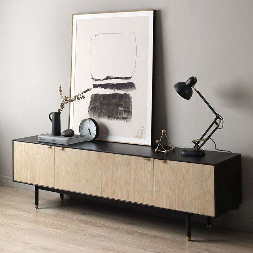 Elegant oak TV stand showcasing four doors and iron legs from a front angle.