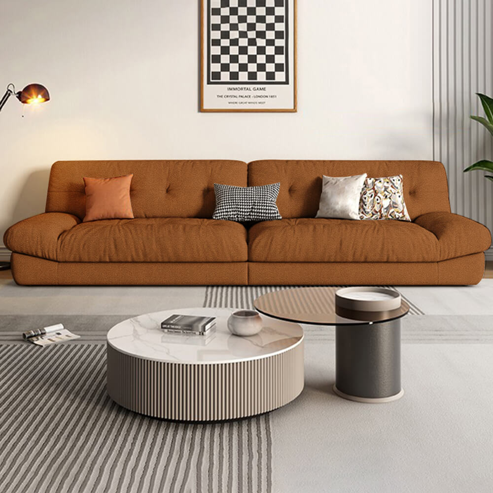 Luxurious brown sofa with wide armrest and pillows, perfect for modern living rooms.