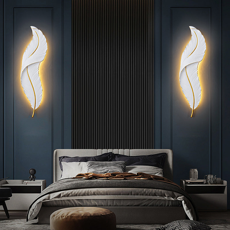 Close-up view of the modern wall sconce showcasing the feather design.
