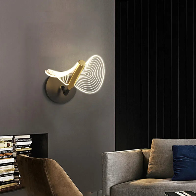 Gold wall light installed in a modern dining room, providing ambient lighting.