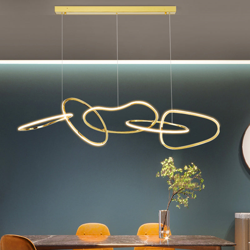 Geometric gold light fixture illuminating a kitchen island.