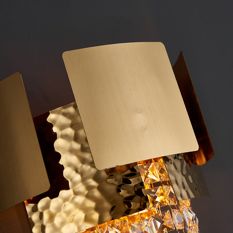 Elegant gold crystal raindrop wall sconce illuminating a modern dining area with a luxurious touch.