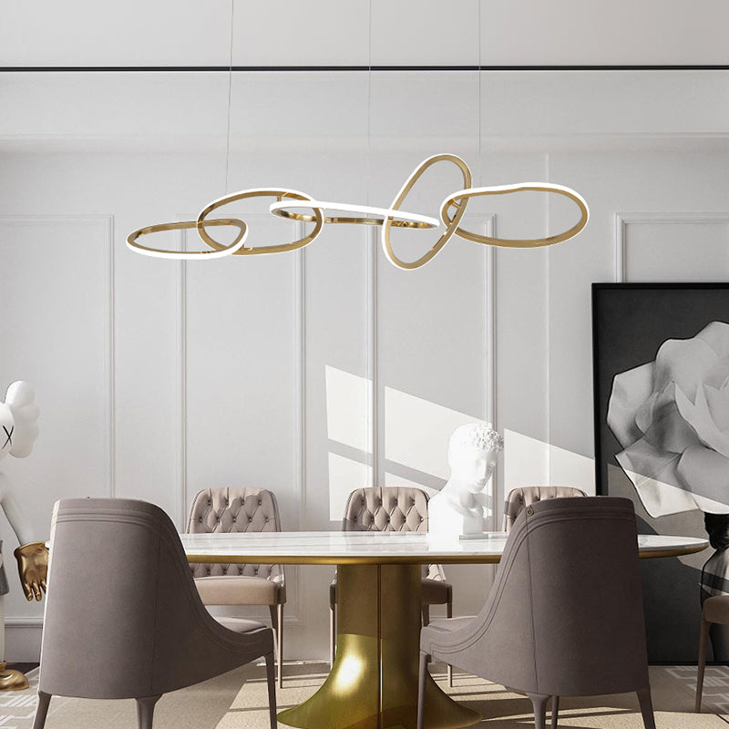 Geometric gold ring LED pendant light hanging over a dining table.