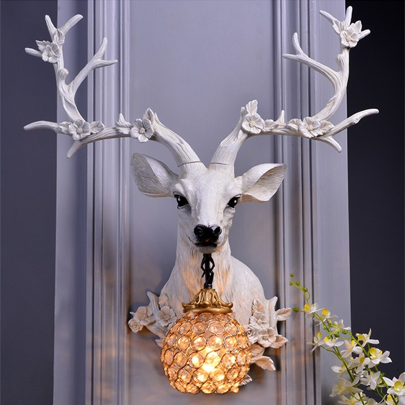 Wall-mounted LED floral deer head lamp glowing softly in rustic entryway decor.